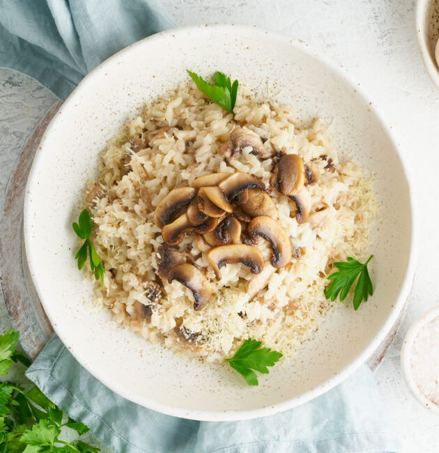 Risotto with mushrooms in plate. Rice porridge with mushrooms and parsley