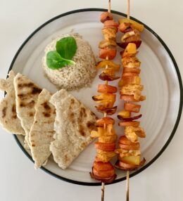 Spicy chicken and vegetable sizzler skewers with rice and flat breads